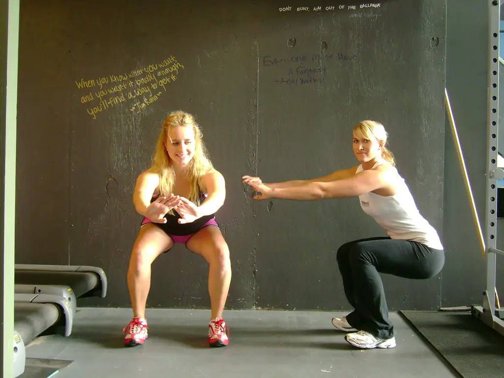 Home leg workouts – two women doing bodyweight squats