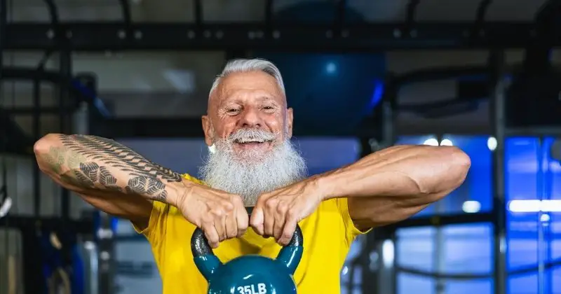 Tricon Training - man with white hair, mustache and beard working out with a kettle bell