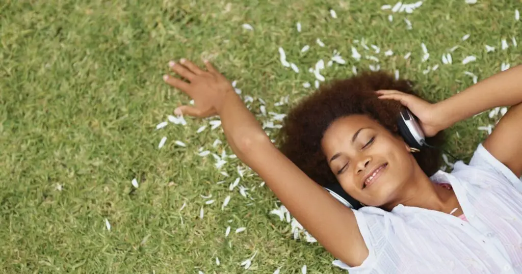 Girl is laying down onto the ground  and relaxing herself